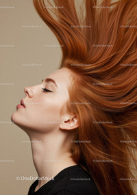 Profile of woman with flowing red hair and closed eyes