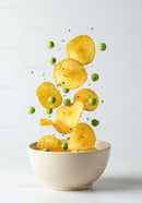 Golden potato chips with green peas in ceramic bowl