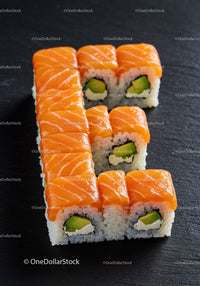 Fresh salmon sushi rolls arranged in letter shape