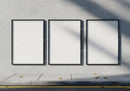 Three Blank Black Frames on Concrete Wall with Sidewalk