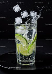 Refreshing lime slices splash in sparkling water glass