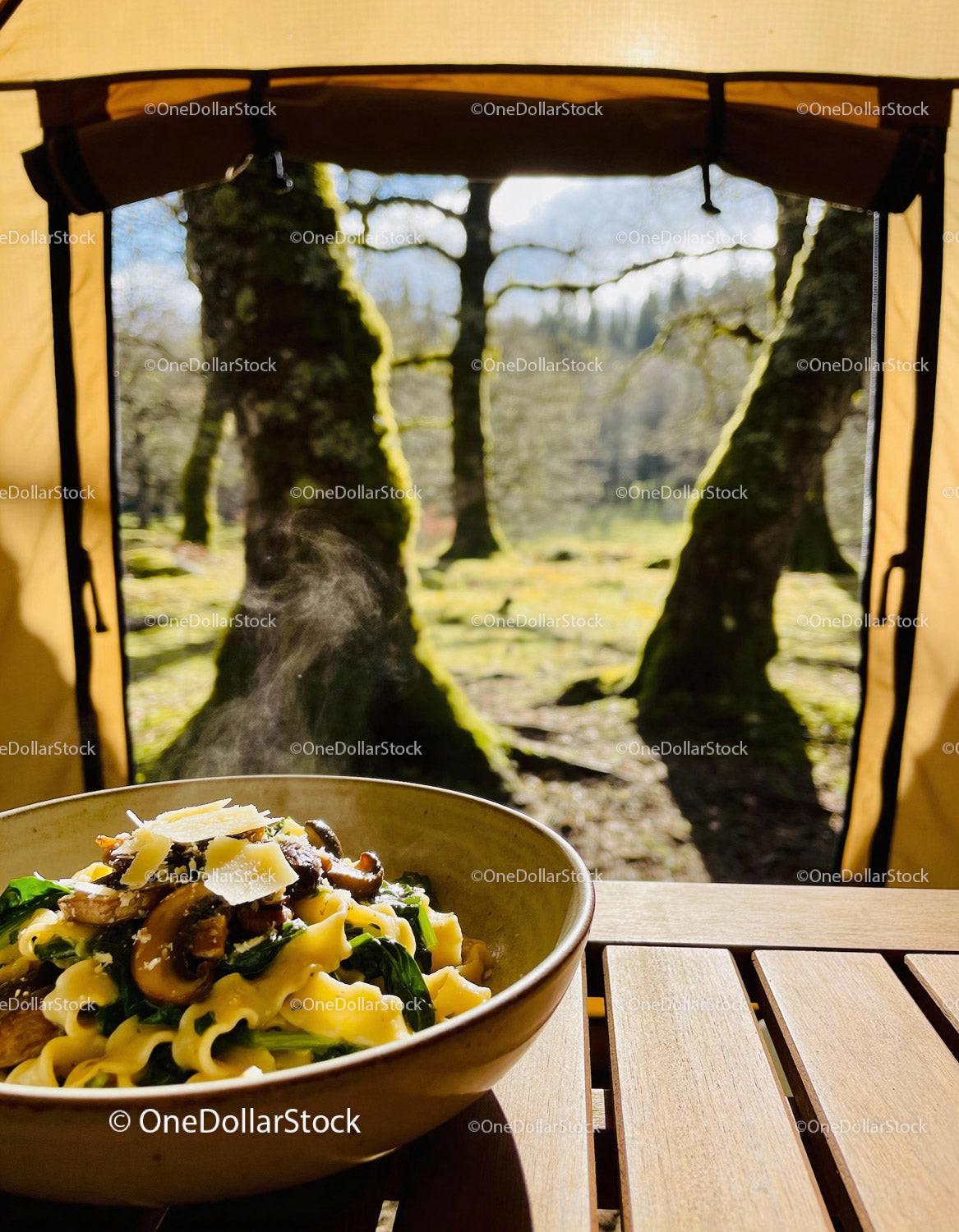 Steaming fresh pasta with mushrooms in forest camp