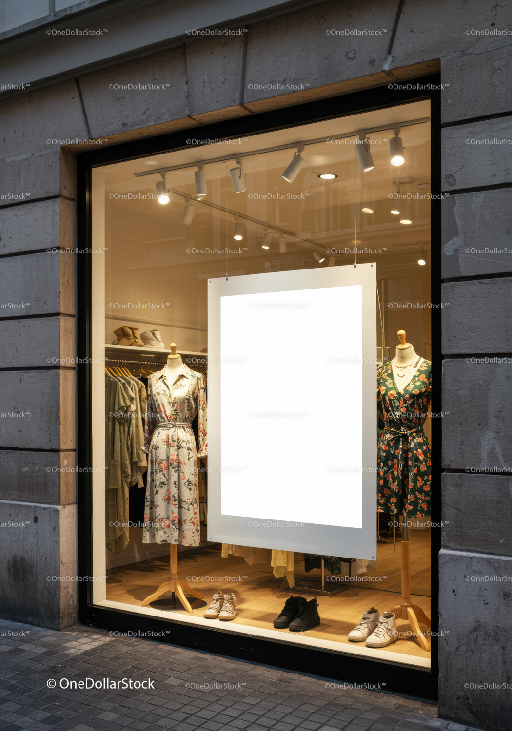 Stylish dresses displayed in illuminated boutique window