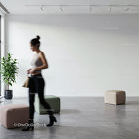 Woman walking past modern pouf seats in minimal interior