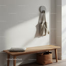 Modern hallway with beige wall, coat hook, wooden bench and storage basket