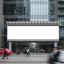 Busy urban street with giant blank billboard on glass building
