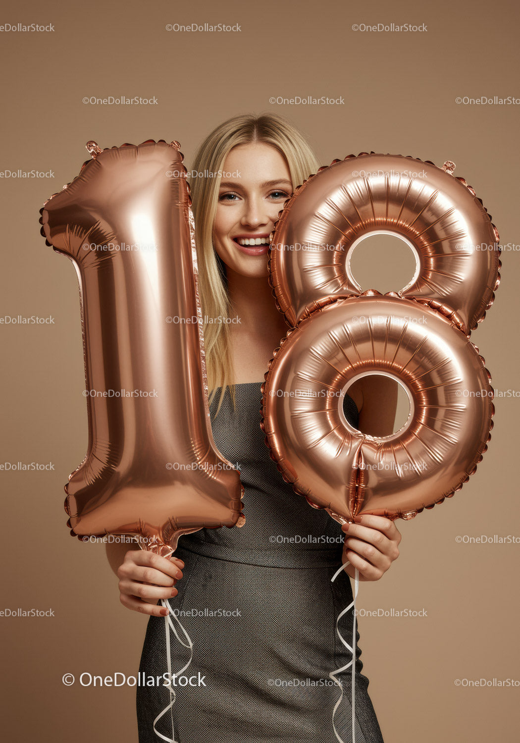 Smiling woman holding 18th birthday number balloons