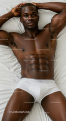 Relaxed muscular man lying on bed in white briefs