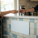 Exchanging Coffee Cup Over Tiled Kitchen Counter