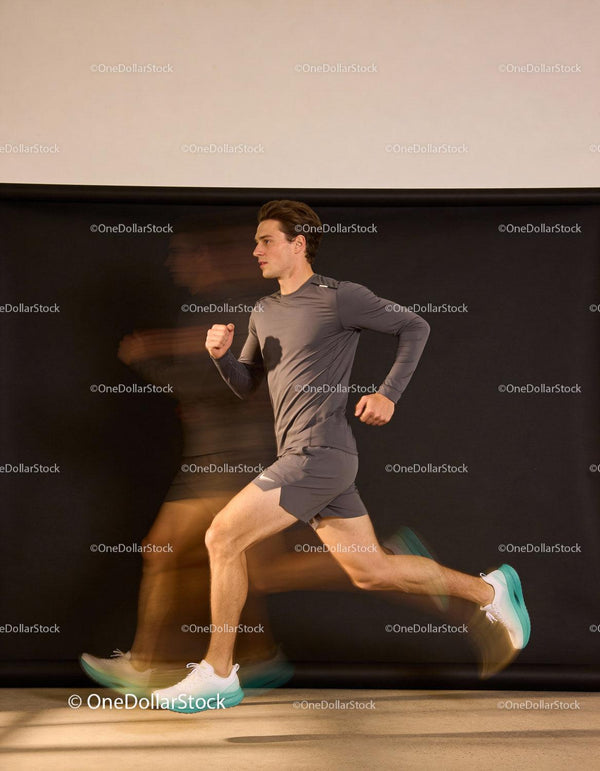 Male athlete sprinting indoors with motion blur effect