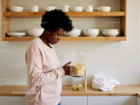 Woman Preparing Fruit Smoothie in Modern Kitchen