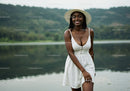 Beautiful Woman in White Dress with Wide-Brim Hat by Lake