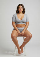 Confident Plus Size Woman Sitting on Stool Wearing Casual Grey Sportswear