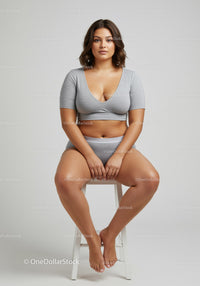 Confident Plus Size Woman Sitting on Stool Wearing Casual Grey Sportswear