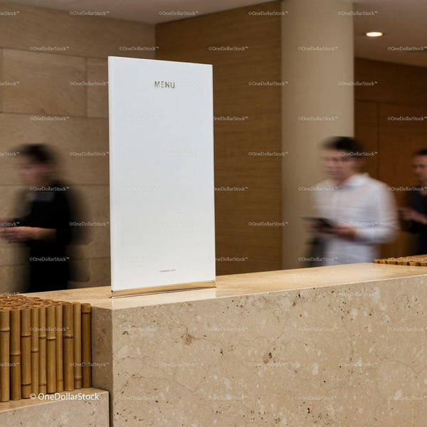 Minimalist white menu on stone counter in busy lobby JPG Mockup Image