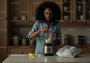 Young Woman Blending Banana Slices for Smoothie in Modern Kitchen