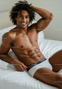 Smiling muscular man relaxing on bed in white underwear