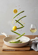 Fresh asparagus and lemon slices cooking in pan