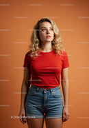 Curly blonde woman in red shirt and denim shorts