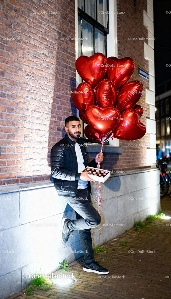 Man with Heart Balloons and Chocolates on City Street