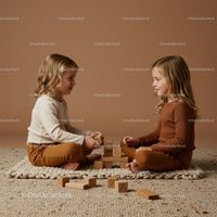 Two young girls playing with wooden blocks indoors