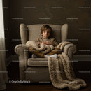 Young boy sitting in cozy chair with knitted blanket