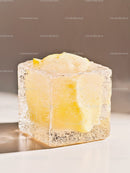 Melting butter cube trapped inside clear ice block