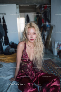 Young Woman Relaxing in Bed Wearing Silk Pajamas In Modern Cozy Room