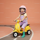 Toddler riding yellow scooter with pink helmet indoors