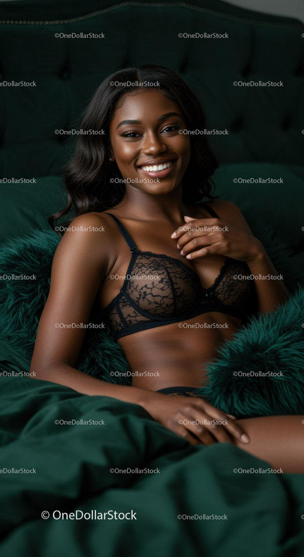 Smiling young woman in black lace lingerie on dark bed