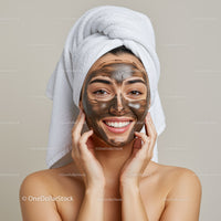 Young Woman Applying Clay Facial Mask with Towel Wrapped Hair