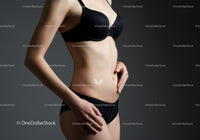 Elegant Woman in Black Lingerie with Toned Body Against Dark Studio Background