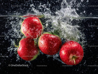 Red apples splashing into water in vibrant action shot