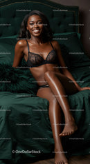 Confident woman relaxing on emerald green bed in black lingerie
