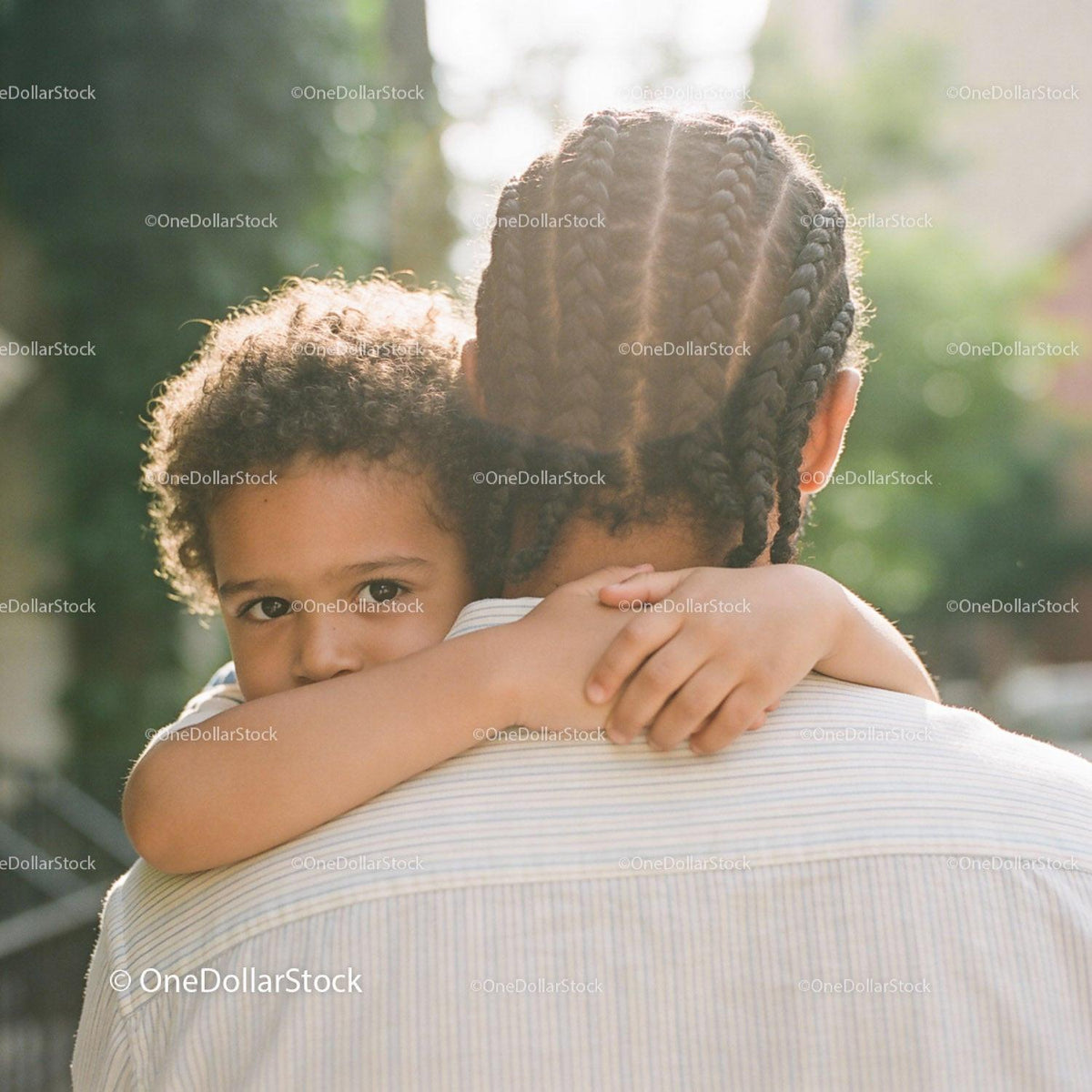 Young child embracing adult in warm outdoor light