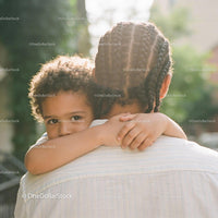 Young child embracing adult in warm outdoor light