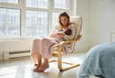 Mother breastfeeding newborn in a sunlit cozy room