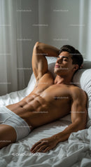Relaxed young man resting peacefully on white bed