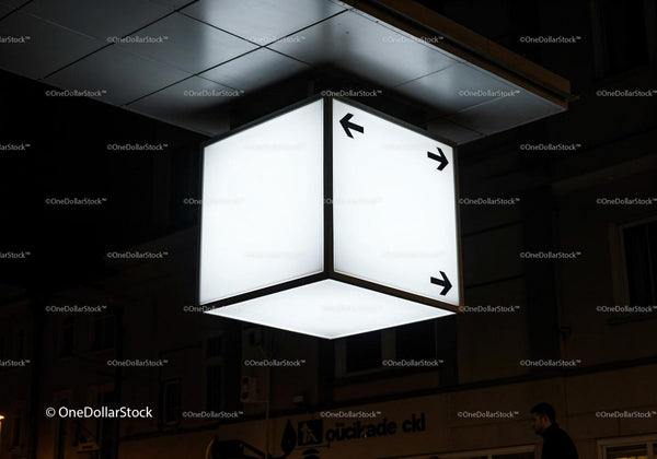 Illuminated directional cube sign glowing in urban night JPG Mockup Image