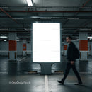 Man walking past illuminated advertising board in parking garage