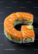 Fresh salmon and avocado sushi roll on dark slate