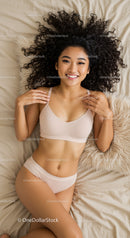 Smiling woman relaxing on bed in comfortable lingerie