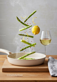 Fresh asparagus and lemon slices toss in frying pan