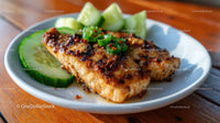 Grilled Fish with Cucumber Slices on Rustic Wooden Table