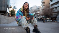 Young Woman Sitting on Urban Steps Using Tablet in Casual Streetwear