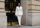 Elegant woman in white suit posing in urban setting