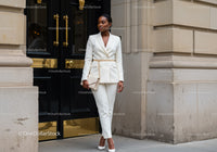 Elegant woman in white suit posing in urban setting