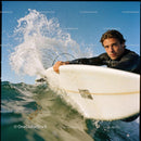 Focused surfer riding a wave with water splash