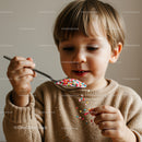 Curious child playing with colorful candy sprinkles