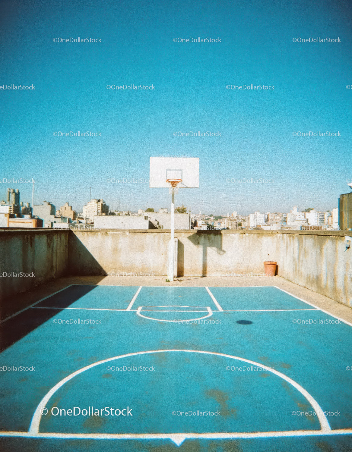 Urban Rooftop Basketball Court with Clear Blue Sky and City View